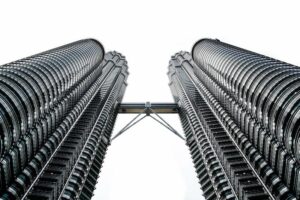 Looking up at the Petronas Twin Towers in Kuala Lumpur, connected by the skybridge between the towers.