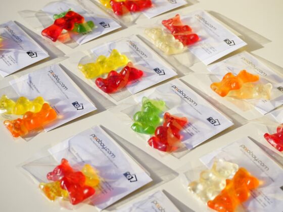 Assorted gummy bear candies in clear packaging laid out on a white surface.